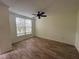 Bright living room with wood-look tile floors, a ceiling fan, and a large window at 6405 Osprey Lake Cir, Riverview, FL 33578