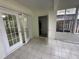 The sunroom has white tiled flooring, screened windows and access to the water heater at 6405 Osprey Lake Cir, Riverview, FL 33578