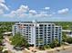 Exterior view of the condo building featuring balconies, lush landscaping, and a well-maintained facade at 700 Beach Ne Dr # 705, St Petersburg, FL 33701