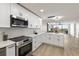 Open-concept kitchen with white cabinets, stainless appliances, marble counters, and an open view to the living area at 700 Beach Ne Dr # 705, St Petersburg, FL 33701