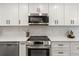 Modern kitchen featuring white cabinets, stainless steel appliances, and beautiful marble countertops and backsplash at 700 Beach Ne Dr # 705, St Petersburg, FL 33701