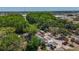 Aerial view of home surrounded by mature trees and landscaping, with a glimpse of city amenities nearby at 705 Cypress St, Tarpon Springs, FL 34689