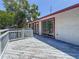 Wide, weathered back deck is attached to a white house with red trim, offering a relaxing outdoor space at 705 Cypress St, Tarpon Springs, FL 34689