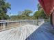 Spacious back deck with a weathered look and views of lush green trees and blue sky at 705 Cypress St, Tarpon Springs, FL 34689