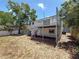 Shot of the home exterior and the dry, open backyard from the corner of the yard at 705 Cypress St, Tarpon Springs, FL 34689