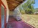 Backyard with a covered patio, staircase to upper level, and lush green surroundings at 705 Cypress St, Tarpon Springs, FL 34689