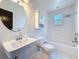 Bright bathroom with white tile, updated fixtures, vanity, and a combined tub and shower at 705 Cypress St, Tarpon Springs, FL 34689