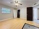 Bright bedroom featuring wood floors, ceiling fan, dark doors and a window at 705 Cypress St, Tarpon Springs, FL 34689