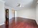 Light-filled bedroom featuring hardwood floors, ceiling fan, closet and a doorway to another room at 705 Cypress St, Tarpon Springs, FL 34689