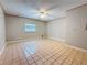 Spacious bedroom with neutral walls, window, and ceiling fan with diamond tiled floors at 705 Cypress St, Tarpon Springs, FL 34689