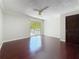 Bright bedroom featuring hardwood floors, ceiling fan and sliding glass doors to a private balcony at 705 Cypress St, Tarpon Springs, FL 34689