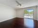 Spacious bedroom featuring hardwood floors, ceiling fan and sliding glass doors to a private balcony at 705 Cypress St, Tarpon Springs, FL 34689
