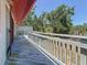 Outdoor deck with wooden railing offering a scenic view of the backyard and mature trees at 705 Cypress St, Tarpon Springs, FL 34689