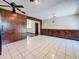 Dining area with wood-paneled accent wall, white tile floor, and custom built-in cabinets at 705 Cypress St, Tarpon Springs, FL 34689