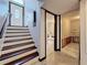 View of the front door and staircase from the entryway, leading to a bathroom and unfinished area at 705 Cypress St, Tarpon Springs, FL 34689