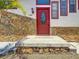 Close-up shot of the red front door and stone accent on the exterior of the house at 705 Cypress St, Tarpon Springs, FL 34689