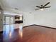 Open living space features hardwood floors, a ceiling fan, and a seamless transition to the kitchen at 705 Cypress St, Tarpon Springs, FL 34689