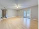Living room with wood floors, ceiling fan, neutral paint, and sliding glass doors to the backyard at 705 Cypress St, Tarpon Springs, FL 34689