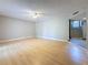 Open living room with wood floors, ceiling fan, neutral paint and an entryway into another room at 705 Cypress St, Tarpon Springs, FL 34689