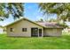 Backyard view of single story home with a large yard and screened in patio at 7517 Oxwood St, North Port, FL 34287