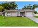 Charming single-story home with a well-maintained lawn and attached garage at 7517 Oxwood St, North Port, FL 34287