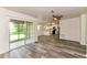 Open-concept living room with updated flooring, leading to kitchen and screened patio at 7517 Oxwood St, North Port, FL 34287