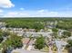 Neighborhood aerial view featuring many homes surrounded by mature trees and a lake at 7903 Lake Placid Ln, Trinity, FL 34655