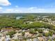 Panoramic aerial shot of a neighborhood featuring homes, trees, and lakes in the distance at 7903 Lake Placid Ln, Trinity, FL 34655