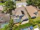 Aerial view of home with a screened pool and lush landscaping at 7903 Lake Placid Ln, Trinity, FL 34655