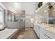 Elegant bathroom featuring a soaking tub, glass shower, and double vanity with marble countertops at 7903 Lake Placid Ln, Trinity, FL 34655