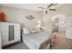 Comfortable bedroom features wood look flooring, ceiling fan, and adjoins ensuite bath at 7903 Lake Placid Ln, Trinity, FL 34655