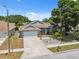 Charming single-story home with well-manicured lawn, gray exterior, and attached two-car garage at 7903 Lake Placid Ln, Trinity, FL 34655