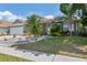 Well-maintained lawn with decorative landscaping, including palm trees, shrubs, and rock garden at 7903 Lake Placid Ln, Trinity, FL 34655