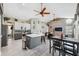 Modern kitchen with gray cabinets, marble countertops, stainless steel appliances, and an island with seating at 7903 Lake Placid Ln, Trinity, FL 34655