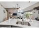 Bright kitchen with marble countertops, stainless steel sink, and an open view of the living area and outdoor pool at 7903 Lake Placid Ln, Trinity, FL 34655