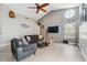 Modern living room features a ceiling fan, large wall mounted television, and cozy furniture at 7903 Lake Placid Ln, Trinity, FL 34655