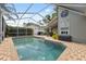 Backyard view of caged pool with brick trim and seating at 7903 Lake Placid Ln, Trinity, FL 34655