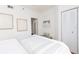 Well-lit bedroom features a comfy bed, a closet, a bench, and stylish artwork at 8000 Sailboat Key S Blvd # 202, St Pete Beach, FL 33707