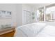 Bright bedroom featuring a comfy bed, bench, a closet, and a large window at 8000 Sailboat Key S Blvd # 202, St Pete Beach, FL 33707