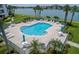 Community pool with lounge chairs and lush landscaping at 8000 Sailboat Key S Blvd # 202, St Pete Beach, FL 33707