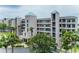 Attractive condo building featuring a well-maintained exterior and lush tropical landscaping at 8000 Sailboat Key S Blvd # 202, St Pete Beach, FL 33707