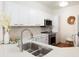 Well-lit kitchen with stainless steel appliances, white cabinets, and a breakfast bar with seating at 8000 Sailboat Key S Blvd # 202, St Pete Beach, FL 33707