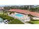 Aerial view of a large pool and clubhouse surrounded by lush landscaping and marina views at 8000 Sailboat Key S Blvd # 202, St Pete Beach, FL 33707