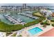 Community pool surrounded by lounge chairs and lush landscaping near marina with boat docks at 8000 Sailboat Key S Blvd # 202, St Pete Beach, FL 33707