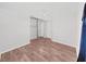 Bright bedroom with wood-look flooring and white walls. Mirrored closet doors create a sense of space at 8124 Golf Club Ct, Hudson, FL 34667