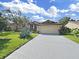 Charming home with a well-maintained lawn and a long driveway leading to an attached garage at 8124 Golf Club Ct, Hudson, FL 34667