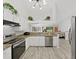 Well-lit kitchen with stainless steel appliances, white cabinetry, and an open view into the living room at 8124 Golf Club Ct, Hudson, FL 34667