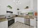 Bright kitchen featuring stainless steel appliances, white cabinets, and decorative plants on top of the cabinets at 8124 Golf Club Ct, Hudson, FL 34667