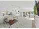 Open-concept living room with light wood floors, white walls and sliding glass doors to lanai at 8124 Golf Club Ct, Hudson, FL 34667