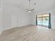 Bright living room featuring modern floors, a ceiling fan, and sliding glass doors leading to a pool at 8124 Golf Club Ct, Hudson, FL 34667